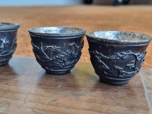Lot 53 - A set of eight Chinese export carved and silver mounted coconut wood wine cups, Qing Dynasty, early 19th century