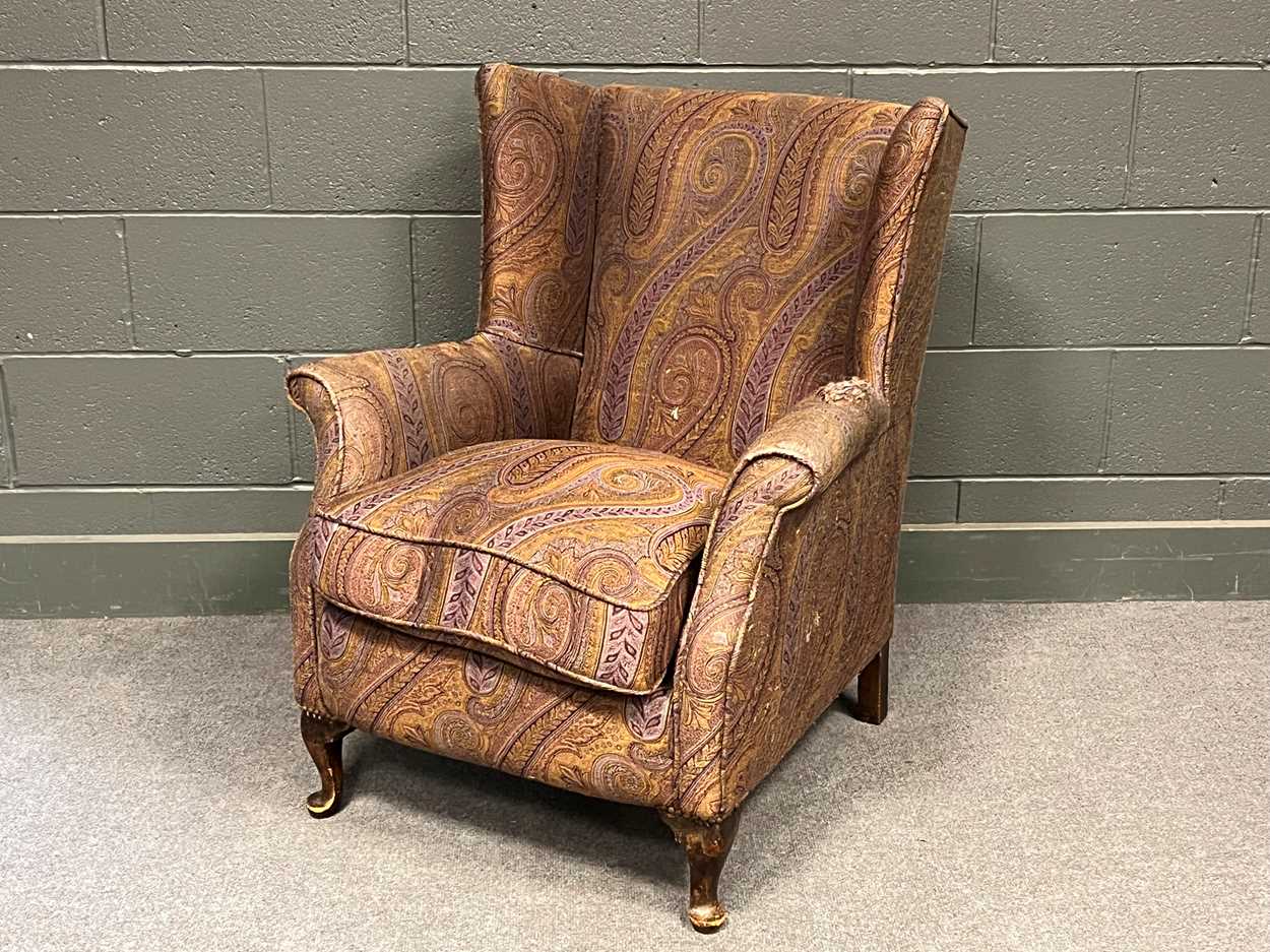 Lot 779 - A small wing back armchair on short cabriole...