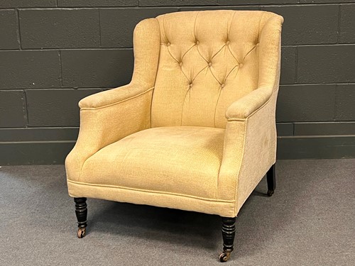 Lot 742 - An buttoned back arm chair with ebonised...
