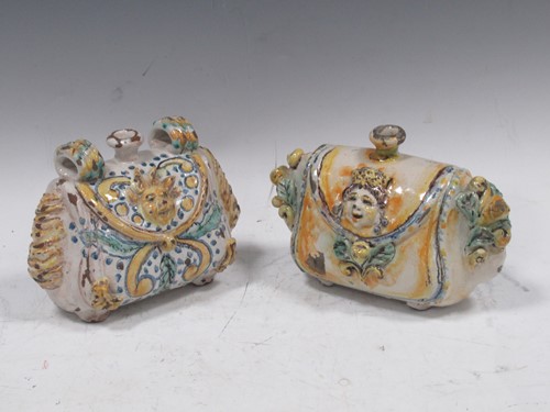 Lot 21 - A near pair of Maiolica satchel form flagons,...