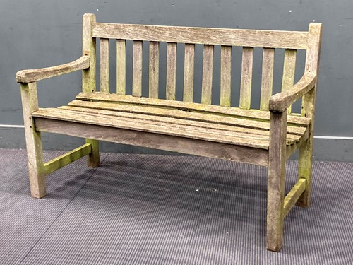 Lot 933 - A modern teak garden bench with slatted seat...