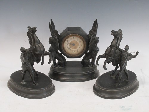 Lot 17 - A bronzed clock garniture, the clock flanked...