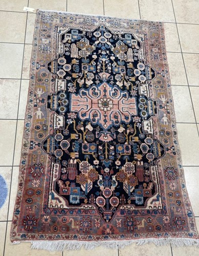 Lot 971 - A red ground Afghan rug with figures to the...