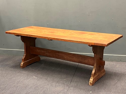 Lot 692 - A three plank refectory table on shaped ends...