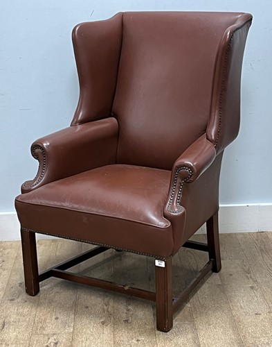 Lot 861 - A modern tan leather wing back armchair