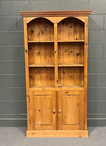 Lot 758 - A pine bookcase, the moulded top above open...