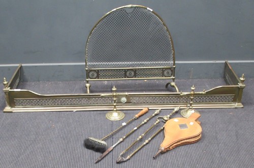 Lot 734 - A pierced work brass fender with urn finials...