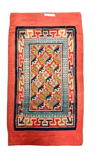 Lot 97 - A Tibetan wool rug circa 1900-1920 with red background