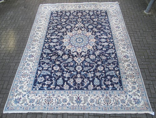 Lot 844 - A Kashan rug with blue ground and pale floral...
