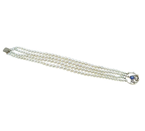 Lot 197 - A four row pearl bracelet with a sapphire and diamond clasp