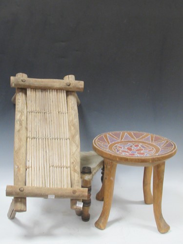 Lot 117 - Three tribal stools, one with four legs and...