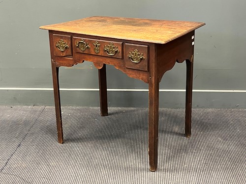 Lot 582 - A George III oak lowboy with two plank top...
