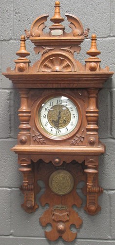 Lot 155 - A carved oak wall clock circa 1900, 105cm high