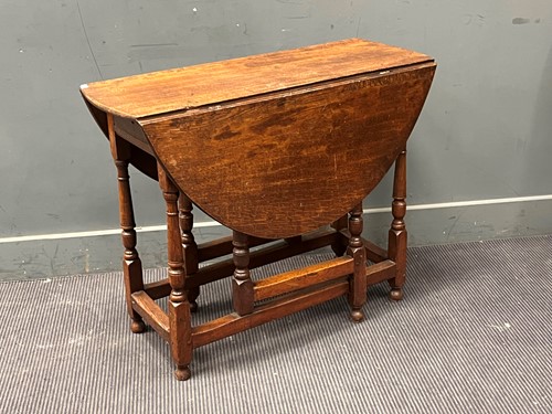 Lot 411 - An 18th century oak drop leaf table, the oval...