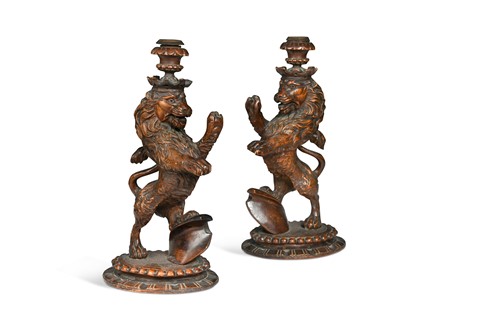 Lot 580 - A pair of carved limewood rampant lion candlesticks, 19th century