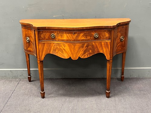 Lot 542 - A Regency style mahogany serpentine sideboard...