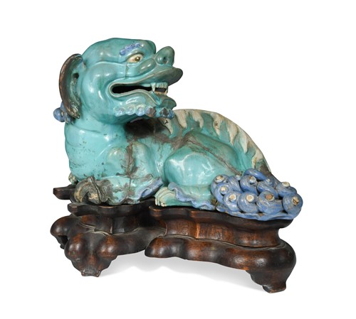 Lot 30 - A Chinese guangdong pottery recumbent kylin, late 19th century