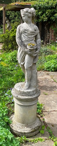 Lot 819 - A reconstituted stone garden statue cast as a young woman carrying a basket, 20th century