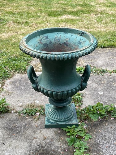 Lot 839 - A pair of green painted cast iron garden urns, early 20th century