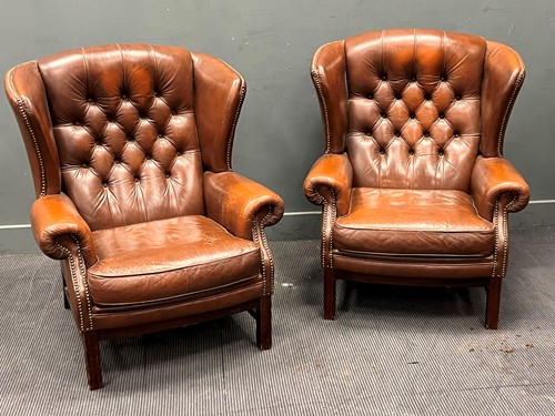 Lot 578 - A pair of brown leather button back wing...