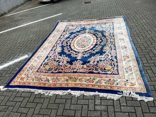 Lot 493 - A machine woven blue ground floral decorated...