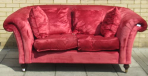 Lot 472 - A red velvet type two seater scroll arm sofa...