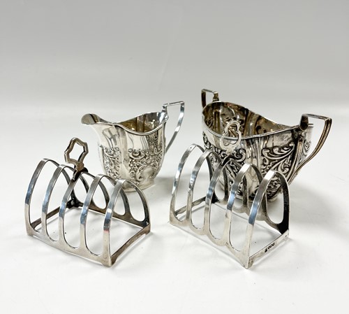 Lot 196 - Two silver toast racks together with a silver...