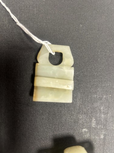 Lot 29 - A Chinese light green jade archaic style belt buckle, Qing Dynasty, 19th century