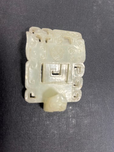 Lot 29 - A Chinese light green jade archaic style belt buckle, Qing Dynasty, 19th century