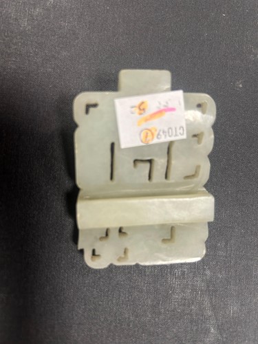 Lot 29 - A Chinese light green jade archaic style belt buckle, Qing Dynasty, 19th century