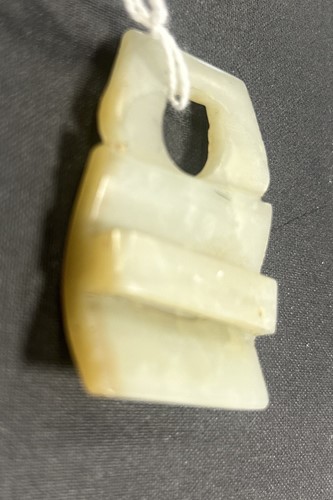 Lot 29 - A Chinese light green jade archaic style belt buckle, Qing Dynasty, 19th century