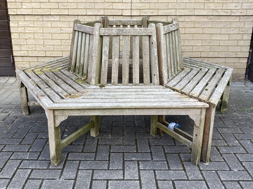 Lot 424 - Teak hexagonal tree bench with slated back and...