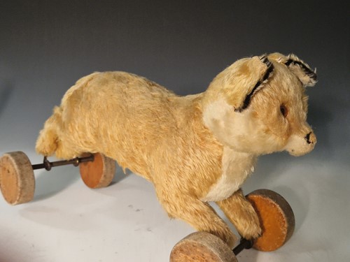 Lot 131 - A vintage Steiff toy fox on wooden wheels