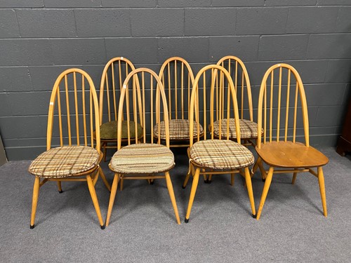 Lot 758 - A set of seven Ercol elm seated dining chairs...