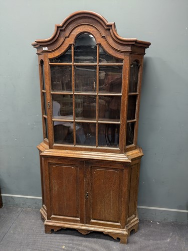 Lot 454 - A Dutch oak glazed top cabinet of shaped arch...