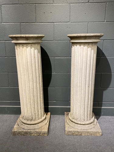 Lot 831 - A pair of stone effect fluted column pedestals with circular tops