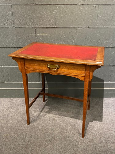 Lot 809 - An Edwardian oak writing table, the inset red...