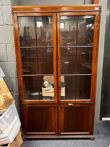 Lot 694 - A walnut glazed two door bookcase, early 20th...