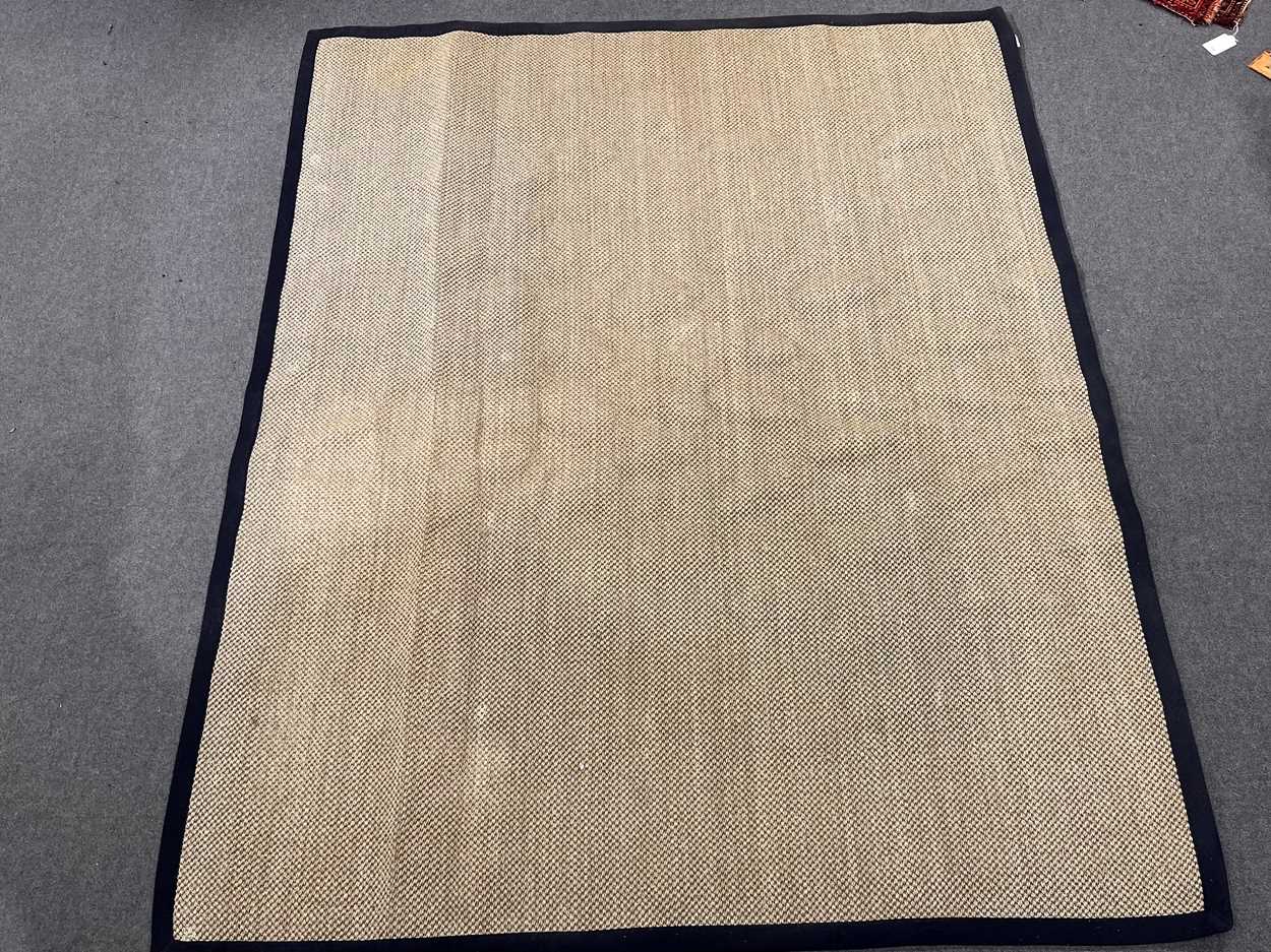 Lot 785 - A large sisal rug with navy contrast bound...