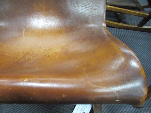 Lot 590 - A Spanish style leather covered chair and foot stool, late 20th century