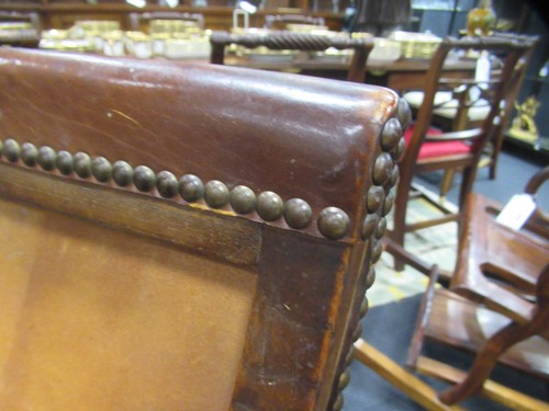Lot 590 - A Spanish style leather covered chair and foot stool, late 20th century