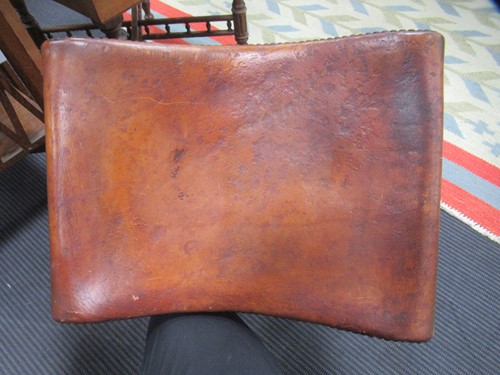 Lot 590 - A Spanish style leather covered chair and foot stool, late 20th century