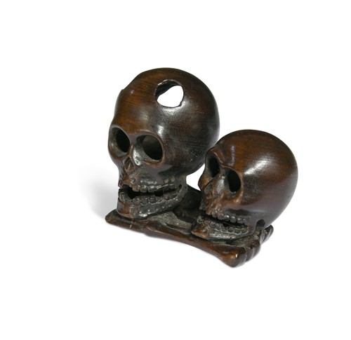 Lot 46 - A Japanese carved hardwood netsuke as two skulls and bones, 20th century