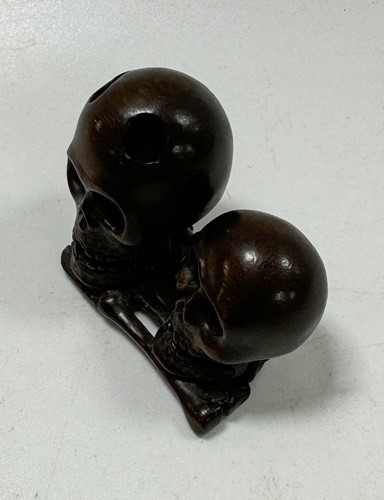 Lot 46 - A Japanese carved hardwood netsuke as two skulls and bones, 20th century