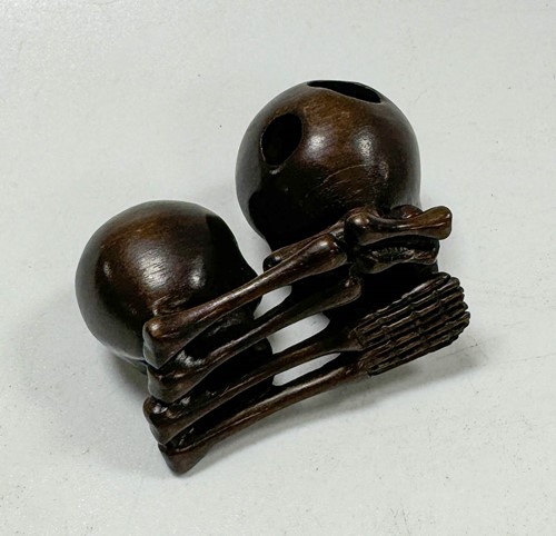 Lot 46 - A Japanese carved hardwood netsuke as two skulls and bones, 20th century