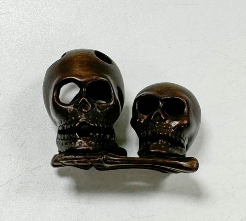 Lot 46 - A Japanese carved hardwood netsuke as two skulls and bones, 20th century