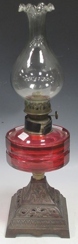 Lot 31 - A late Victorian oil lamp with Cranberry glass...