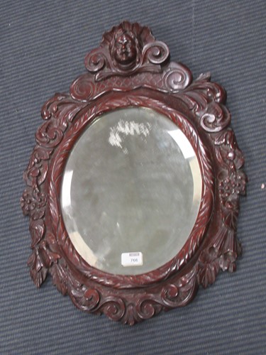Lot 766 - A Continental oval mirror with cherub crested...