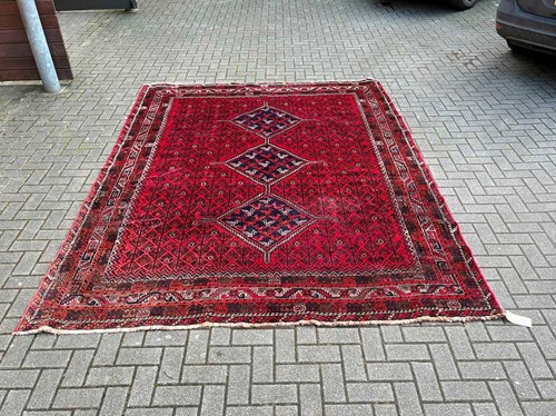 Lot 771 - A Persian Shiraz carpet mainly reds, the...