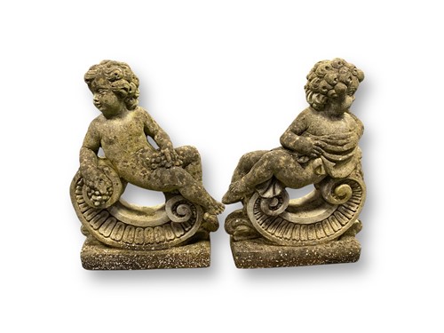 Lot 794 - An opposing pair of composite stone cherubs...